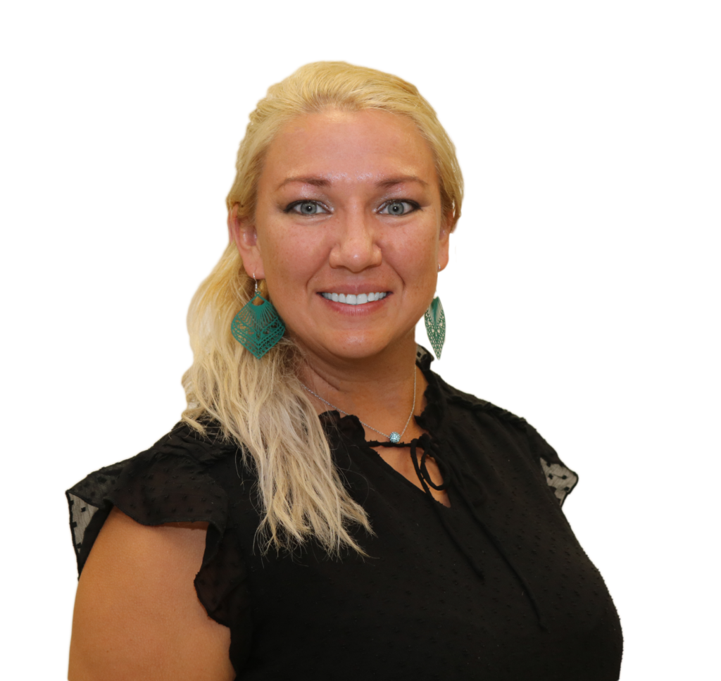 The image shows a woman smiling against a plain white background. She has long, blonde hair styled in a loose ponytail over her shoulder. She is wearing a black, short-sleeved blouse with subtle dotted textures and ruffle details at the shoulders. Her accessories include large, teal-colored statement earrings and a delicate necklace with a small turquoise pendant. Her expression is friendly and approachable, and the overall image has a professional tone, likely intended for formal or business purposes.